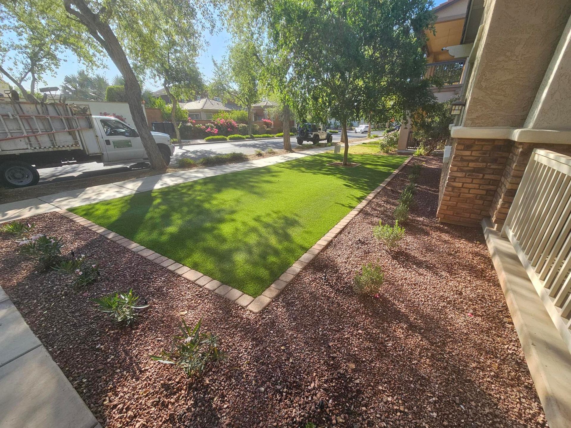 A truck is parked in the driveway of a house next to a lush green lawn.
