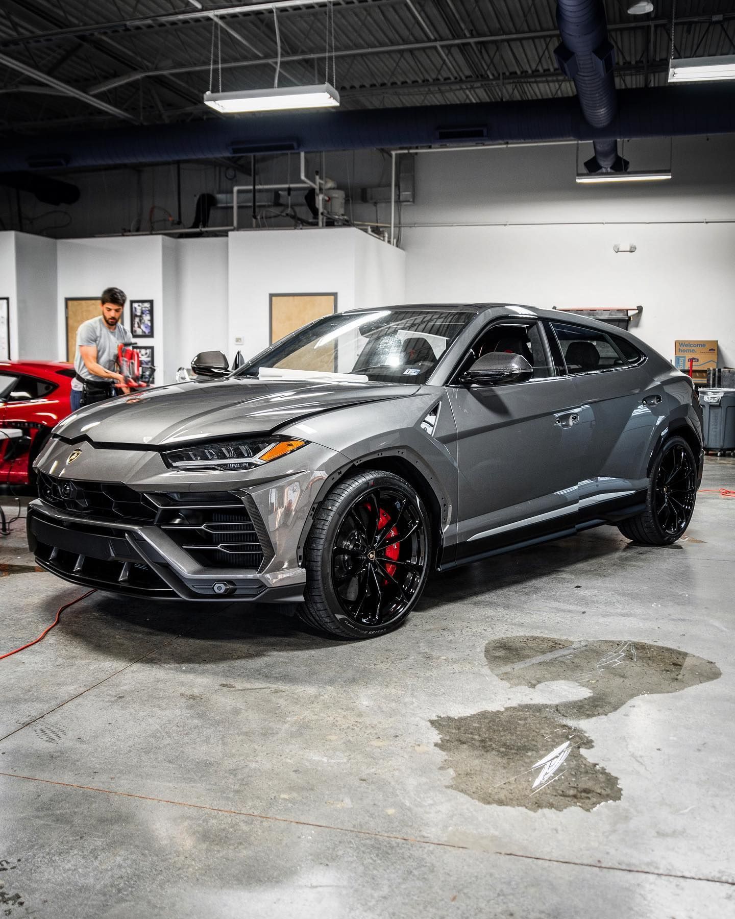 Gray sports SUV in a garage, shown at an angle with black wheels and red brake calipers.