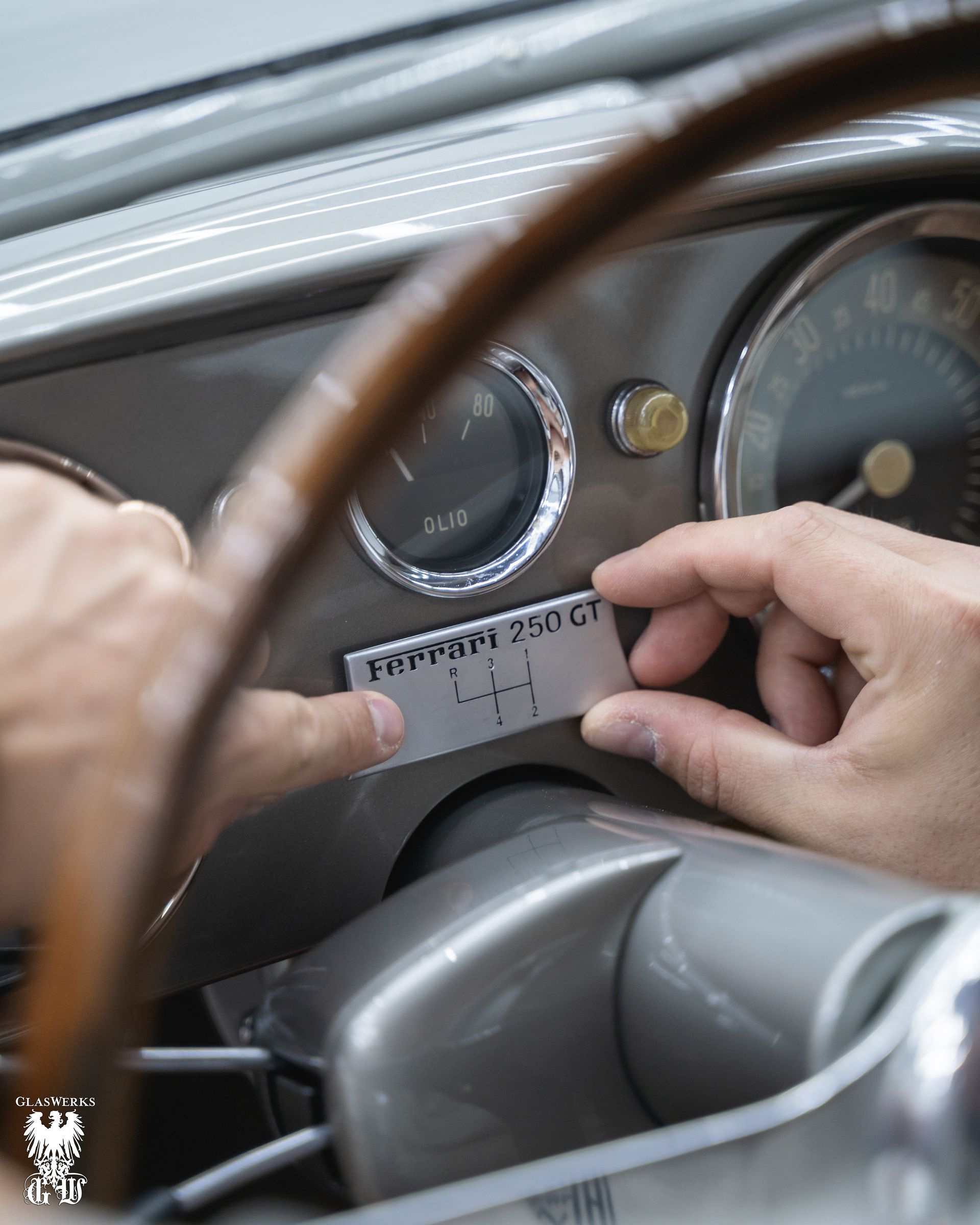 A person is holding a piece of paper that says ferrari on it