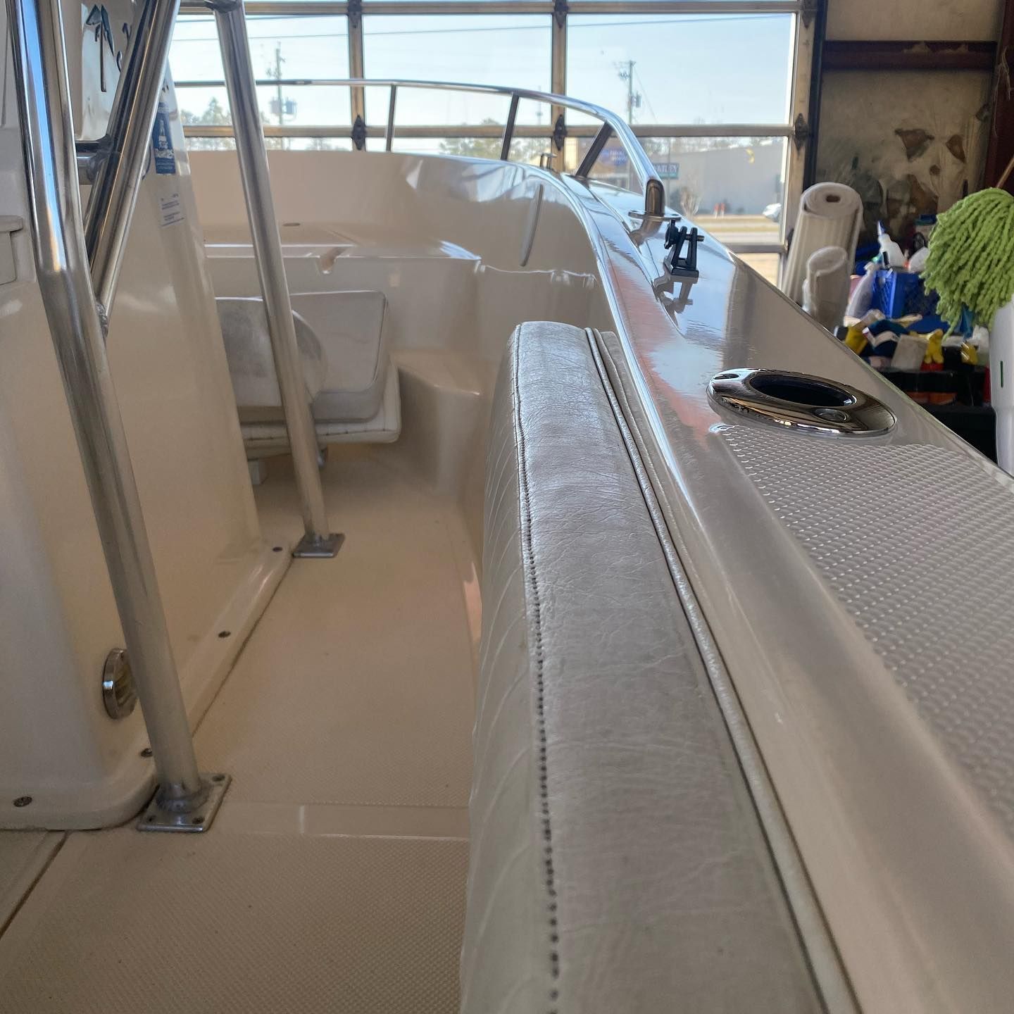 Inside a white yacht cabin, looking toward the helm and sunlit windows.