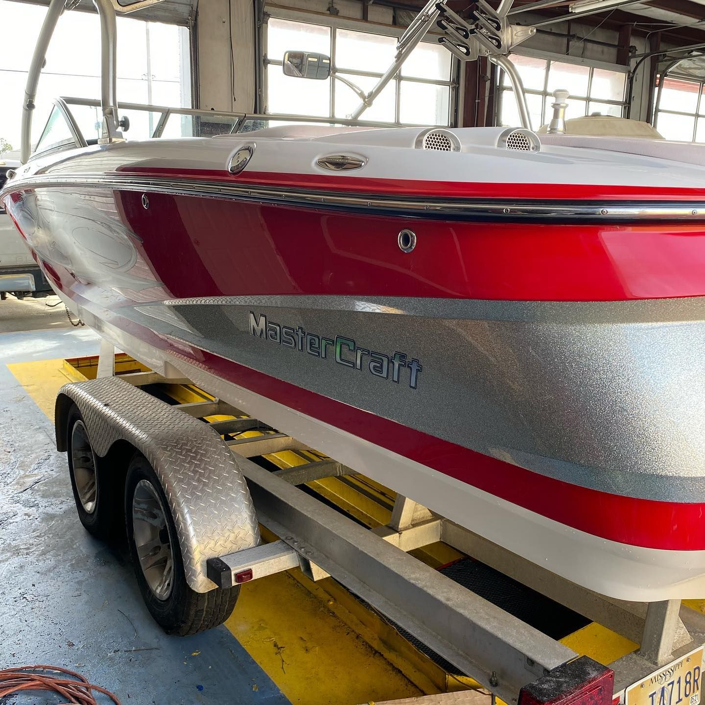 Red and silver speedboat on a trailer inside a storage garage