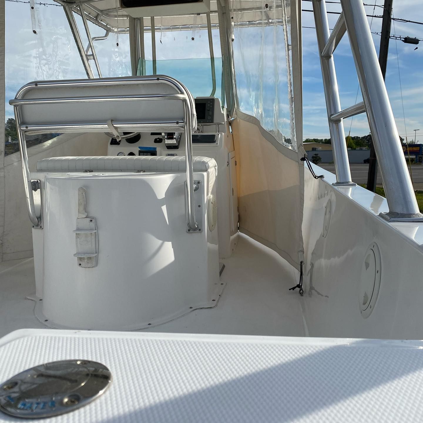 Boat deck with white seating and canopy, looking out over the ocean.