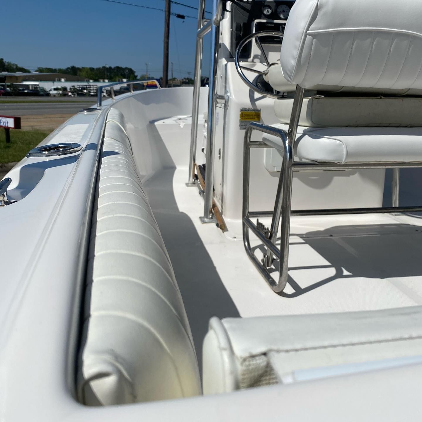 White boat deck with cushioned seats and metal railings in bright sunlight