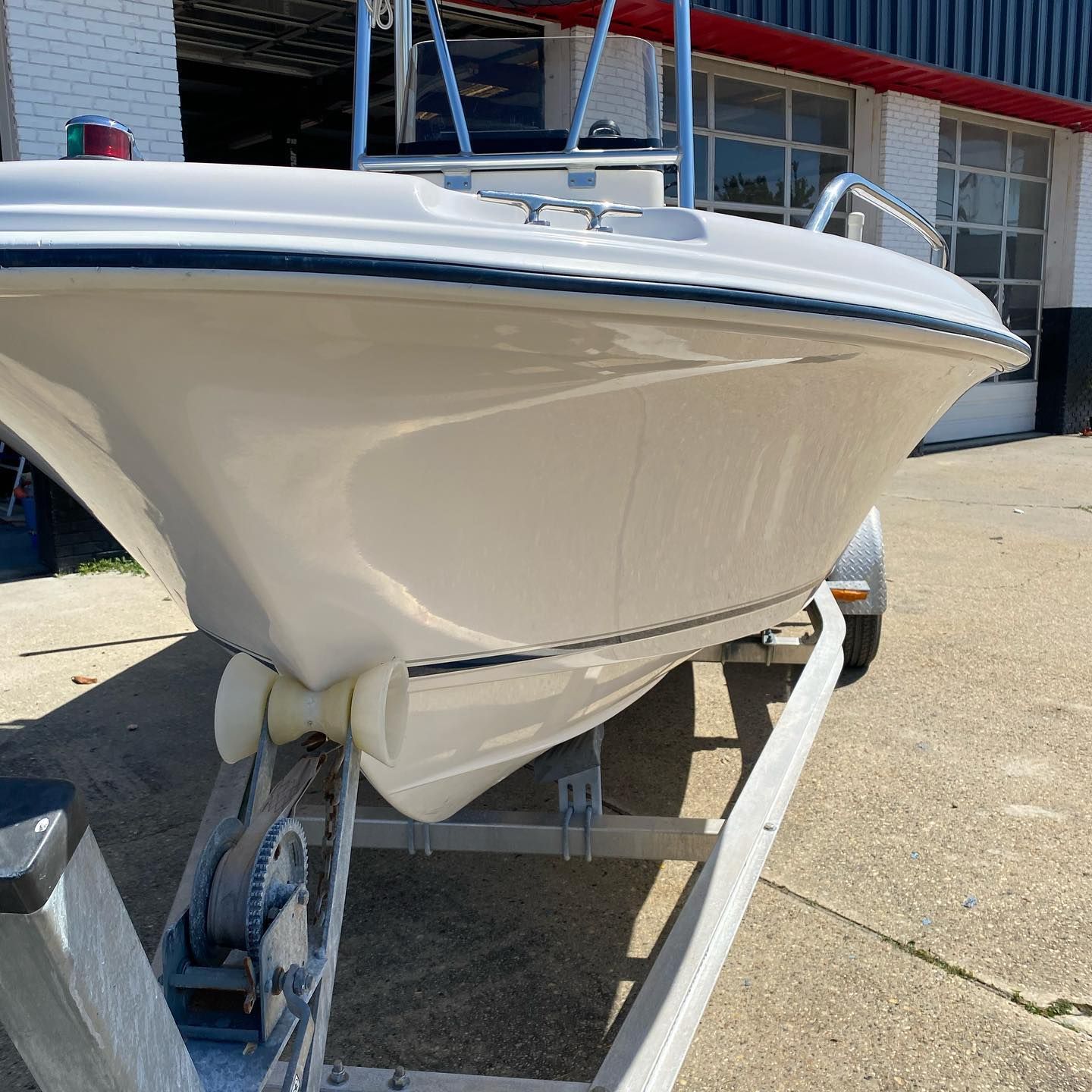 White boat on a trailer parked in a driveway