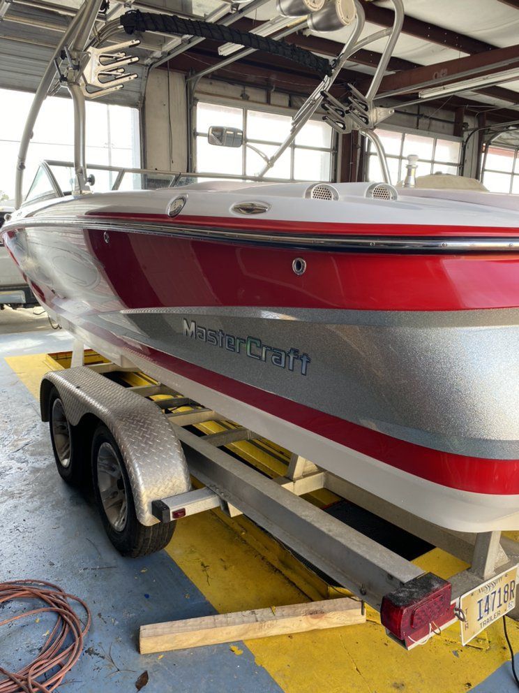 Red and silver boat on a trailer inside a covered storage area