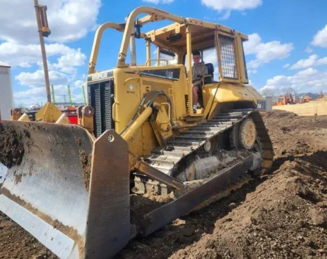 A bulldozer is sitting in the dirt on a construction site.