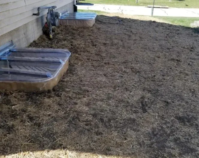 A large pile of dirt is sitting in front of a house.