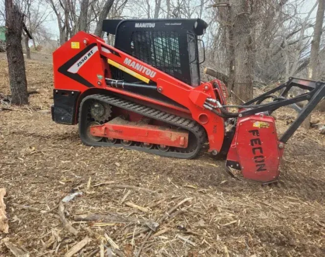 A manitou tractor is sitting in the middle of a forest