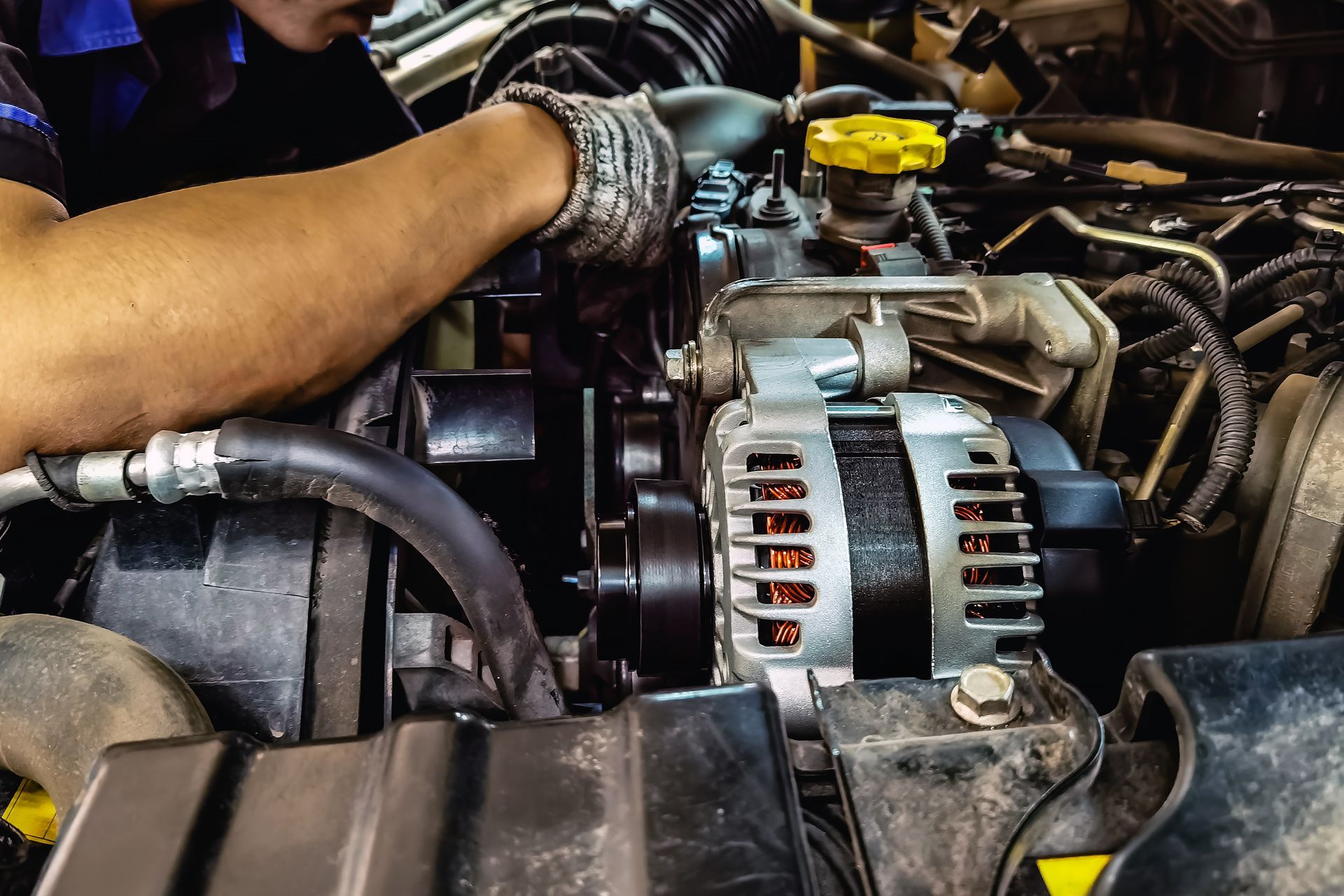 Mechanic working on car engine, focusing on the alternator. Mechanic working on car engine, focusing on the alternator.