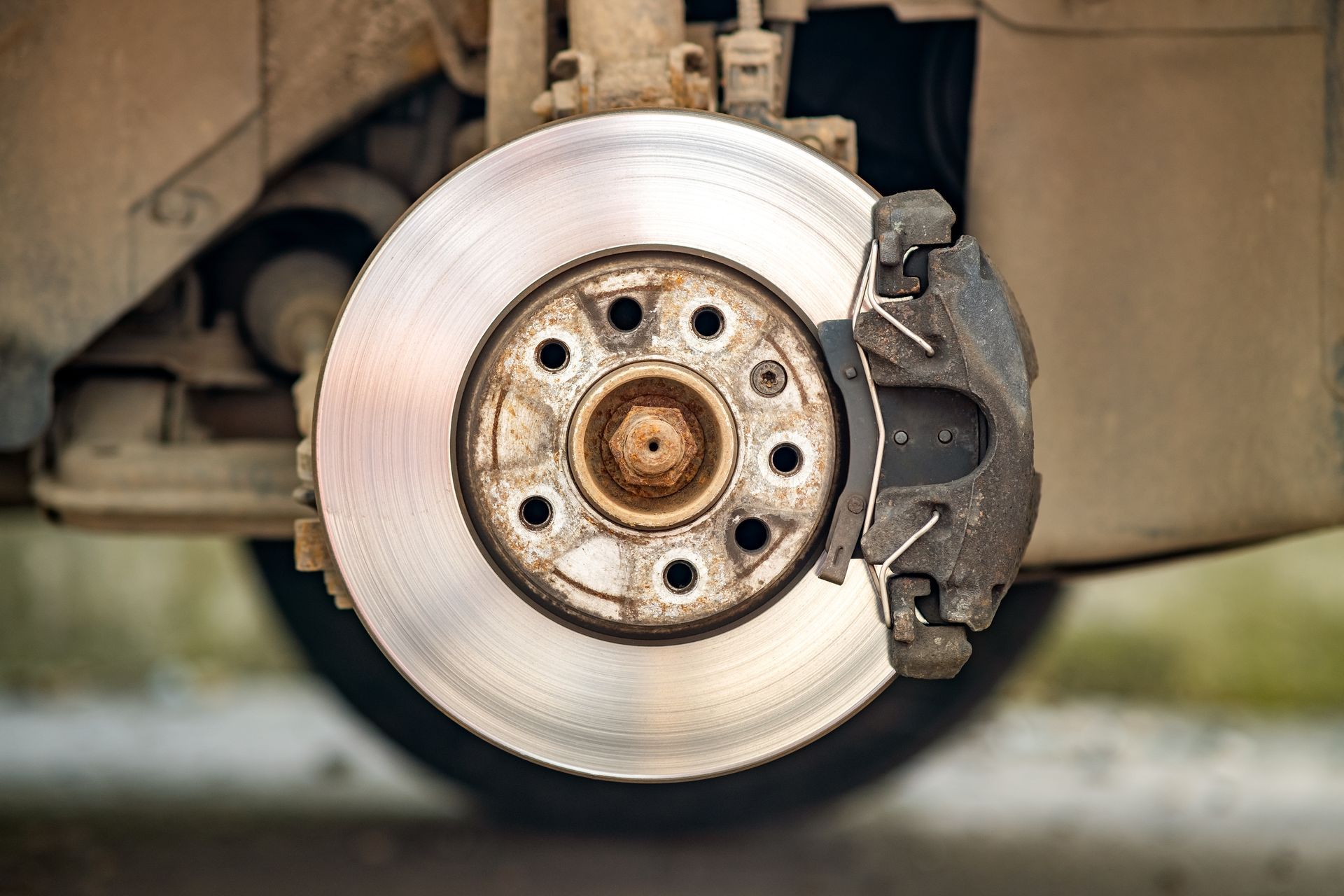 Close-up of a car's brake rotor and caliper, showing wear and tear. Close-up of a car's brake rotor and caliper, showing wear and tear.