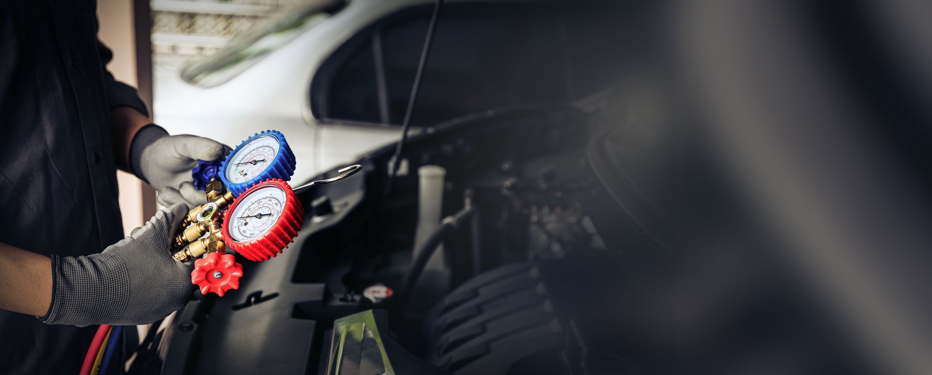 Person working on a car engine with a screwdriver. Person working on a car engine with a screwdriver.