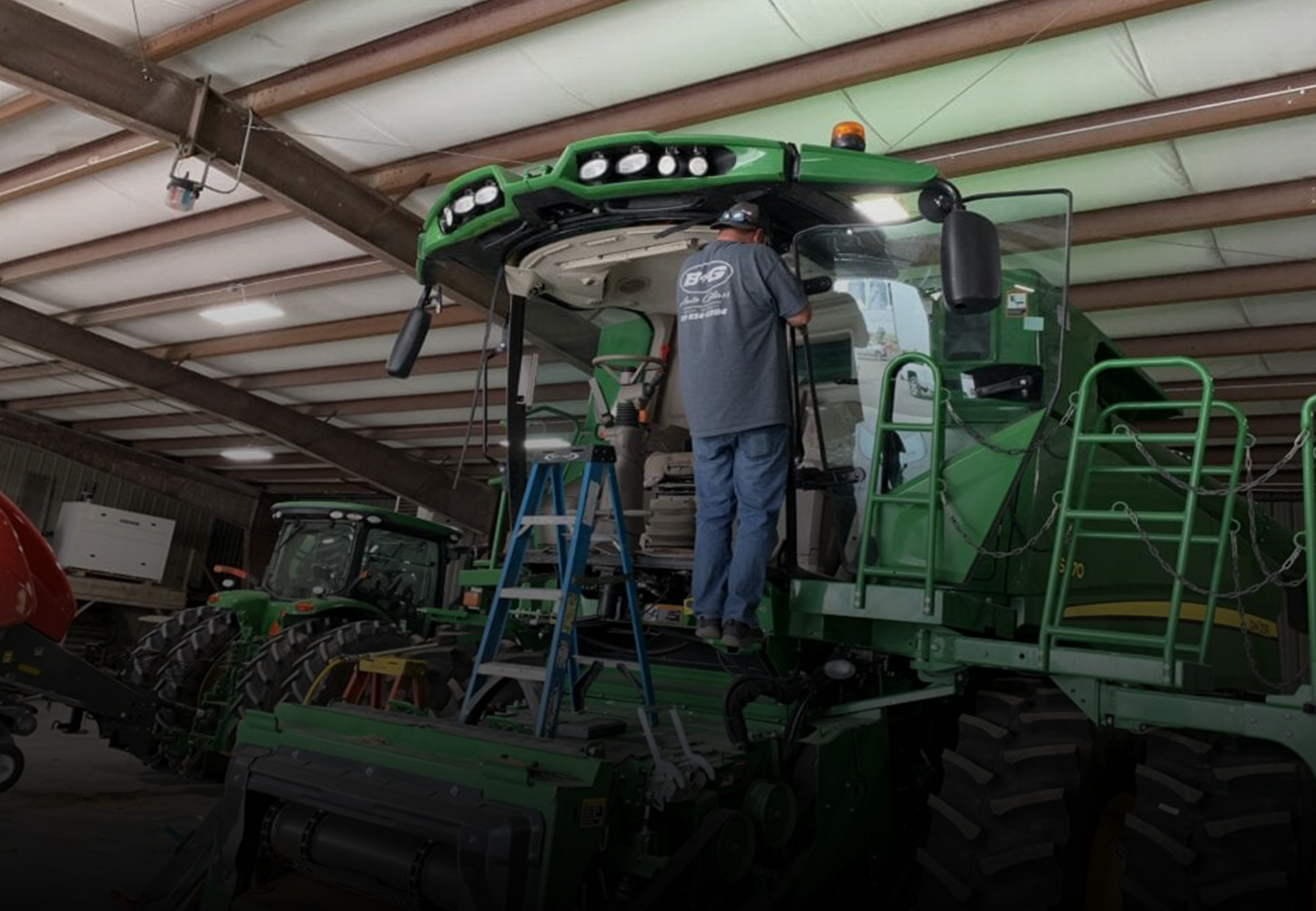 Technician working on large vehicle glass installation at Betts Garage
