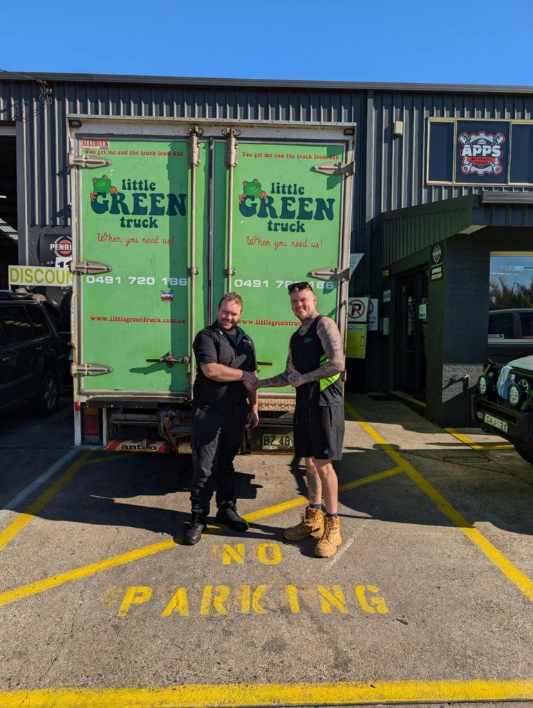 Two Men Are Shaking Hands in Front of a Green Truck — Little Green Truck Port Macquarie in Bonny Hills, NSW