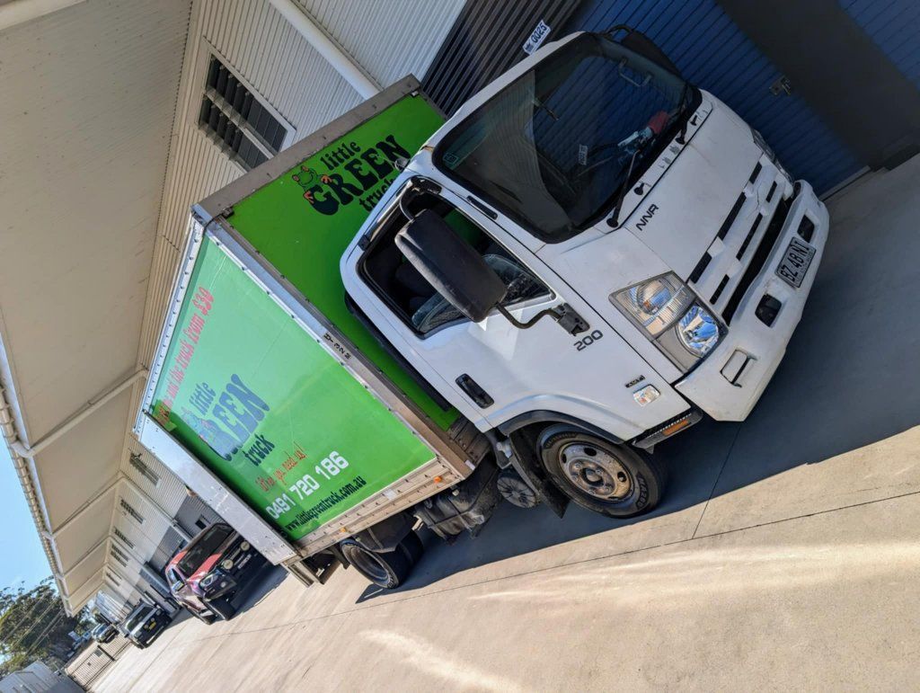 A Green and White Truck is Parked in Front of a Building — Little Green Truck Port Macquarie in Port Macquarie, NSW