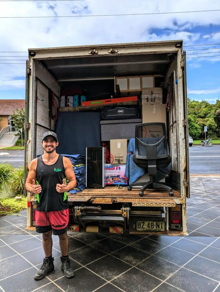 A Man is Standing in Front of a Truck Filled With Furniture — Little Green Truck Port Macquarie in Port Macquarie, NSW