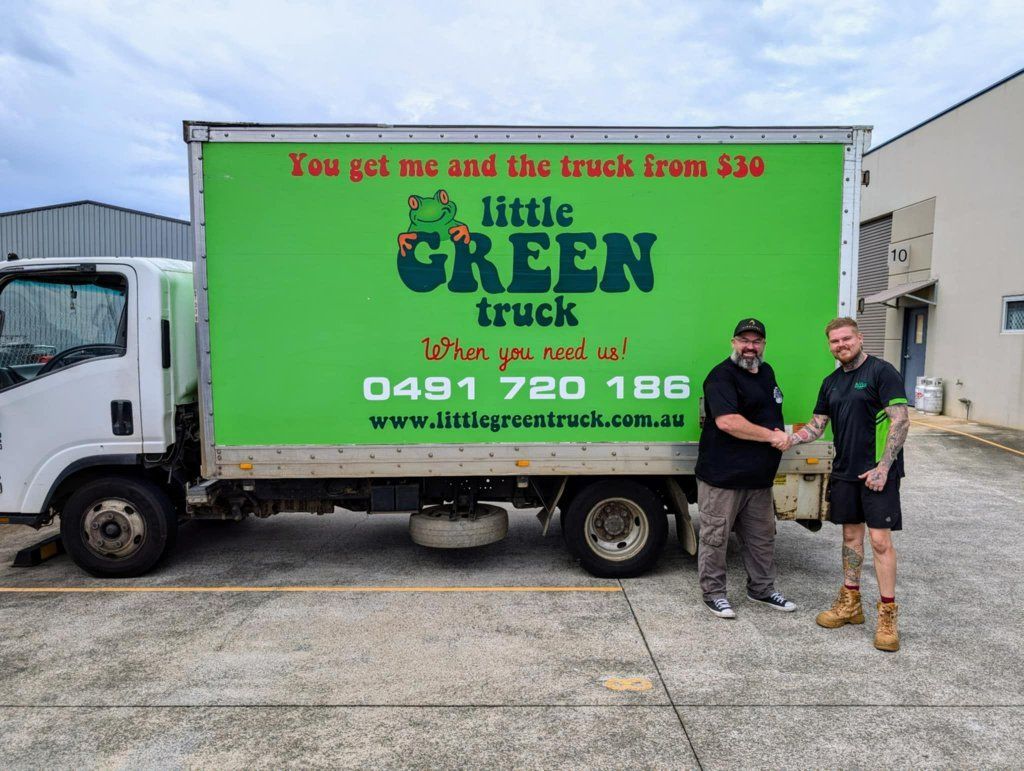 Two Men Are Shaking Hands in Front of a Little Green Truck — Little Green Truck Port Macquarie in Port Macquarie, NSW