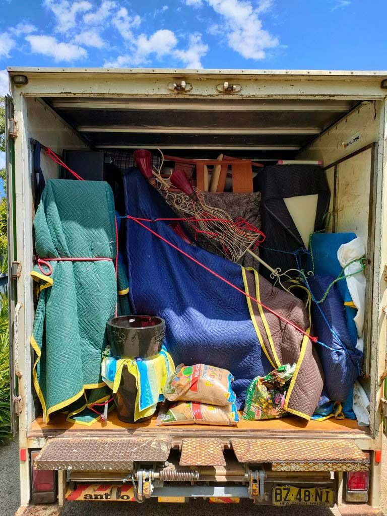The Back of a Moving Truck Filled With Furniture and Blankets — Little Green Truck Port Macquarie in Crescent Head, NSW