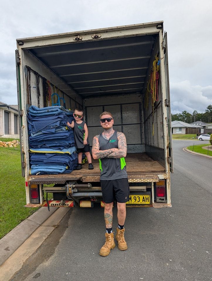 A man and a woman are standing in front of a little green truck — Little Green Truck Port Macquarie in Port Macquarie, NSW