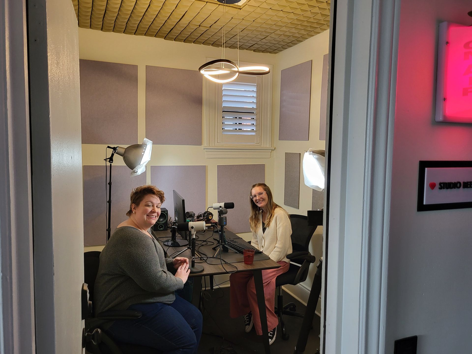 Two women are sitting at a table in a room.