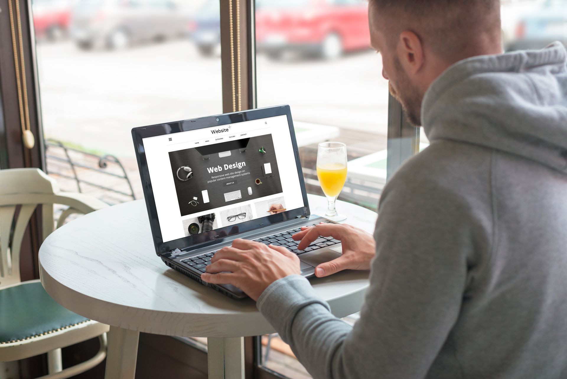 A man is sitting at a table using a laptop computer.