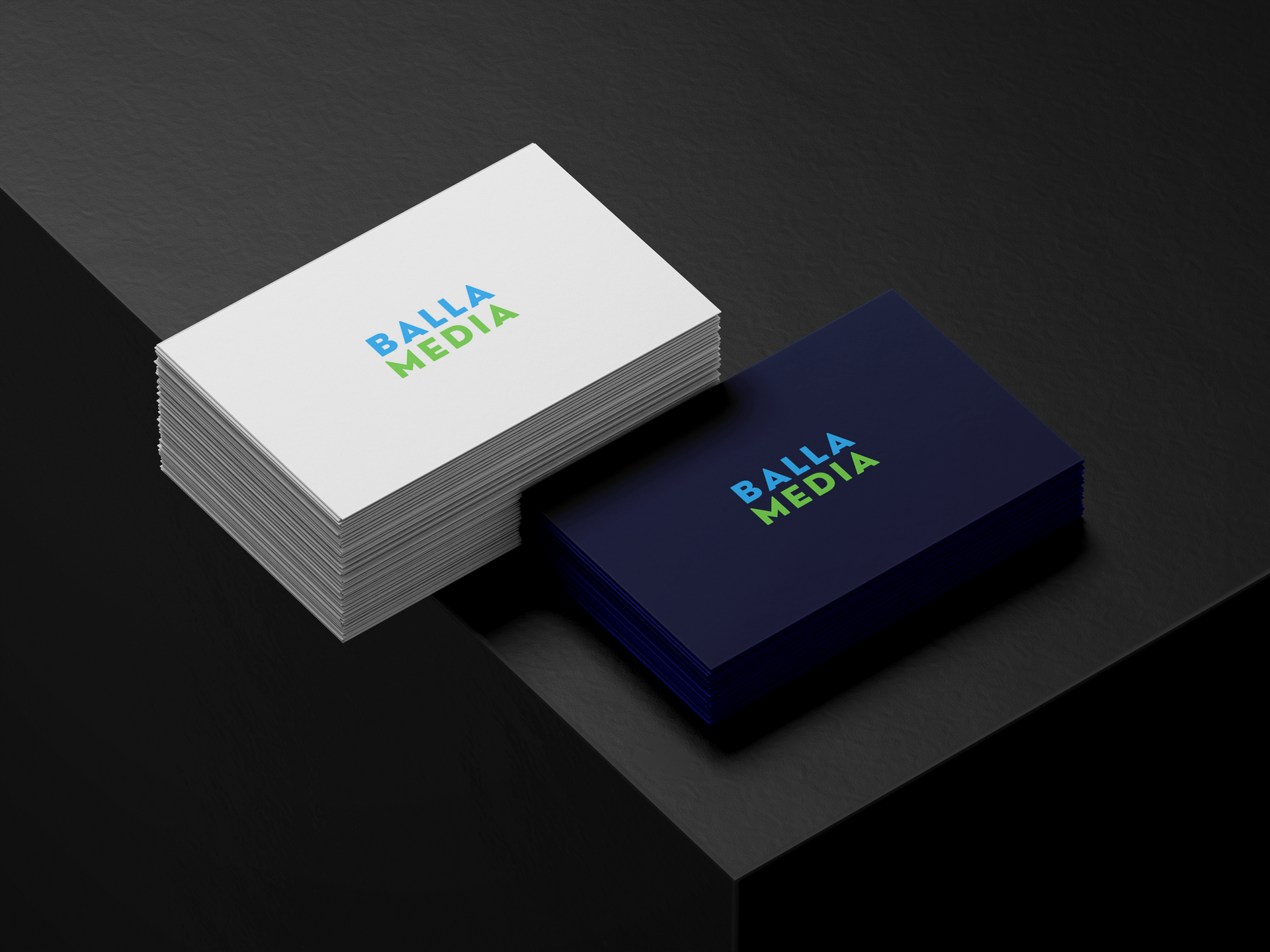 Stacked business cards with blue and white designs on a dark surface, labeled “Balla Media.”