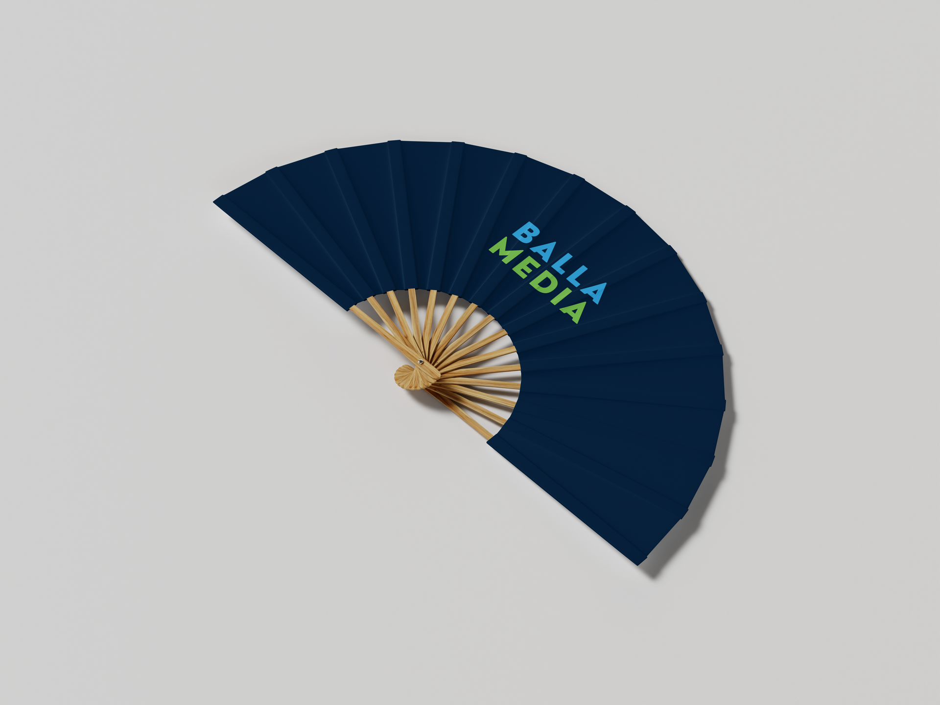 Blue folding fan with gold accents and “BILA MEDIA” text on a light background