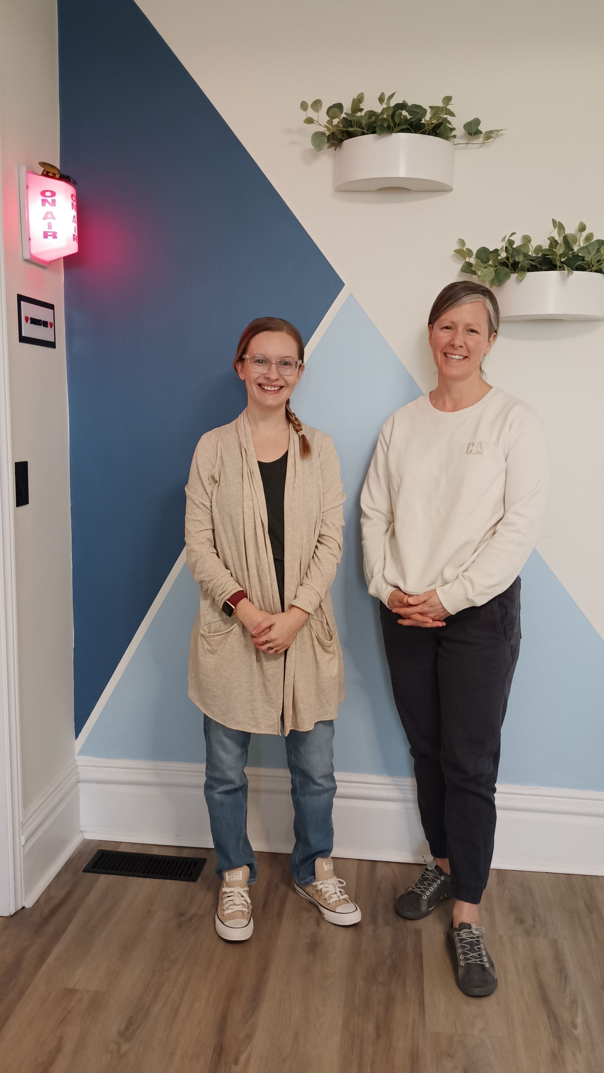 Two women are standing next to each other in a room.
