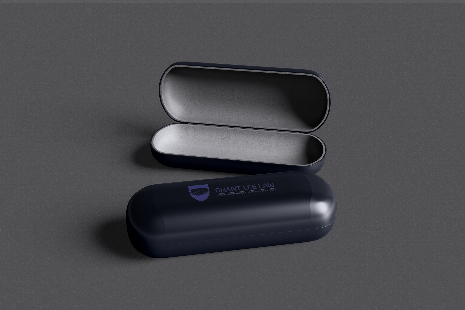 Open black oval case with a silver interior, shown on a dark gray background.
