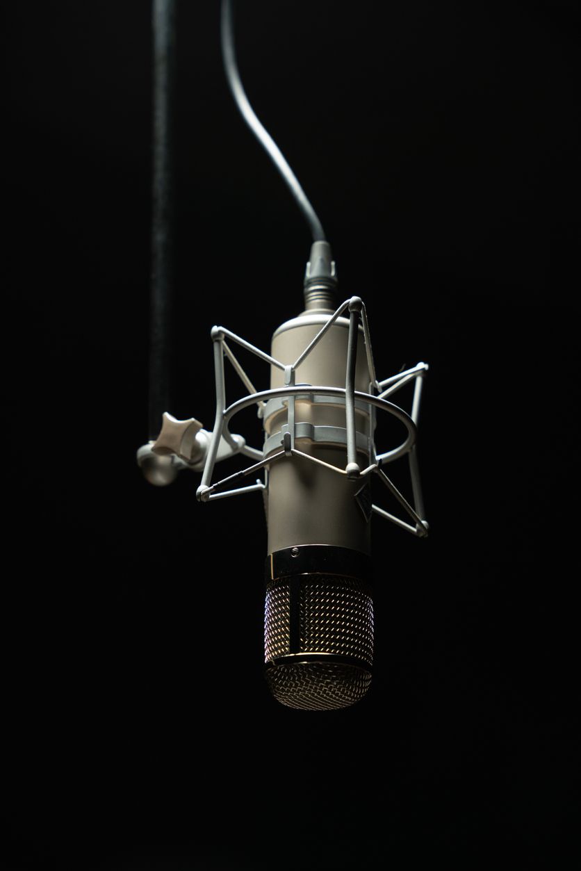 A microphone is hanging from a wire in a dark room.