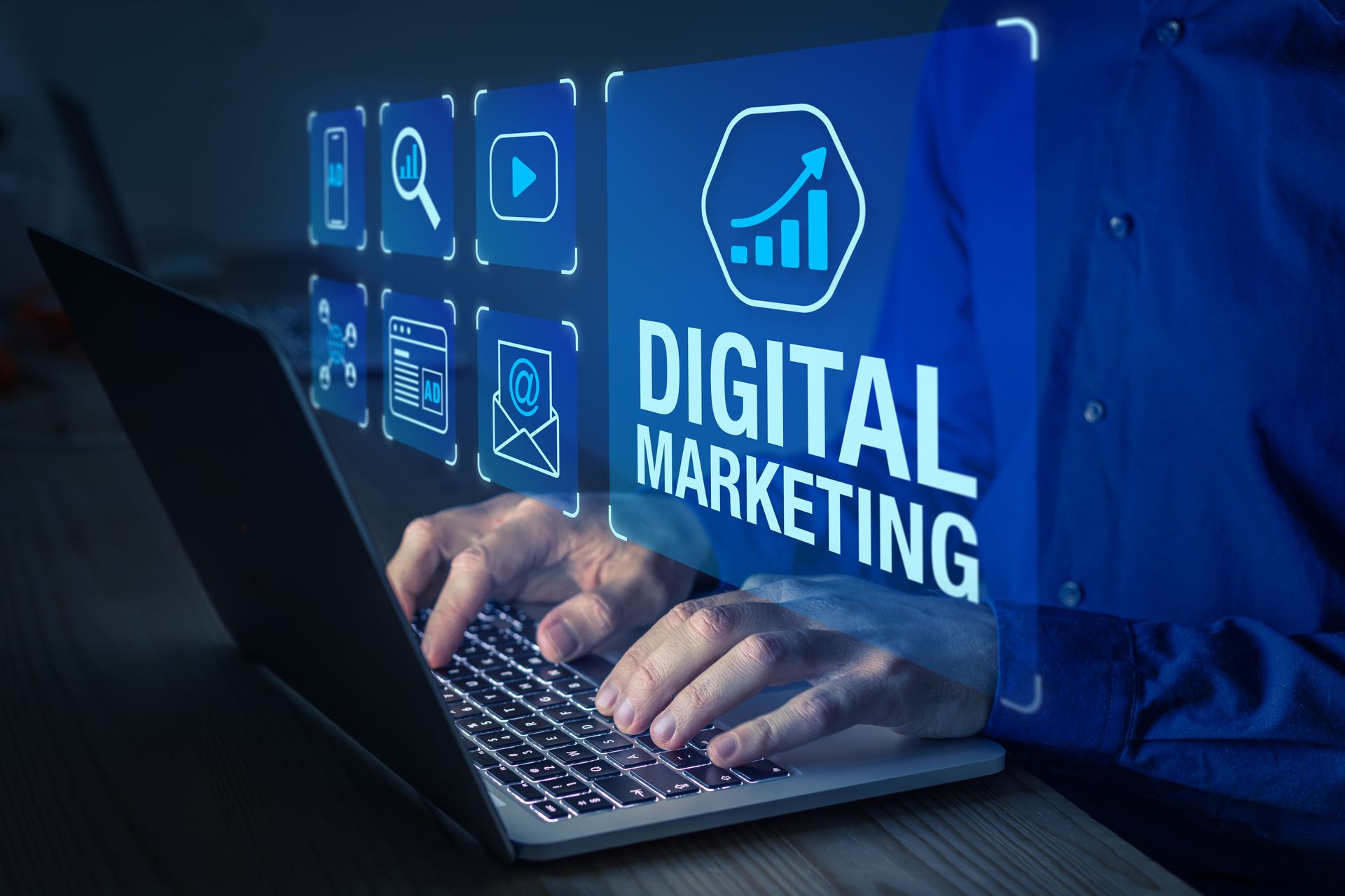 A person is typing on a laptop computer with the words digital marketing coming out of the screen.