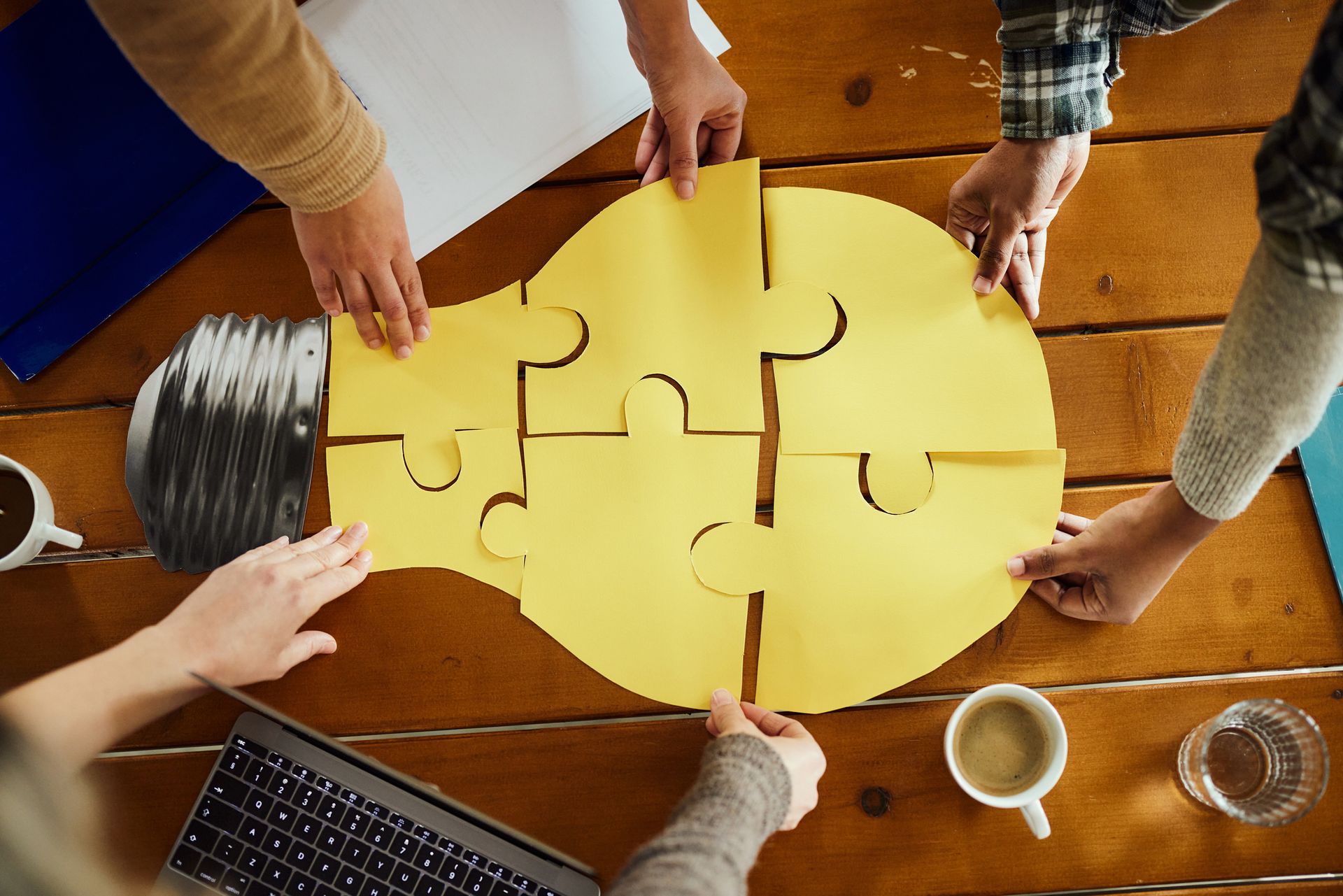 A group of people are putting together a puzzle in the shape of a light bulb.