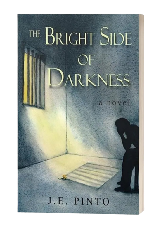 Book cover of “The Bright Side of Darkness” by J.E. Pinto, showing a figure in a dim hallway lit by a bright window.