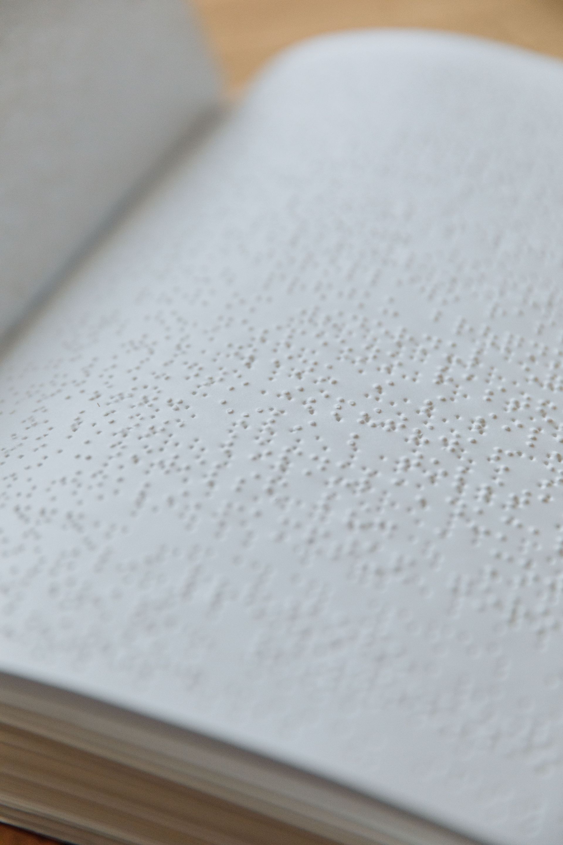 Close-up of an open Braille book with raised dots on white pages