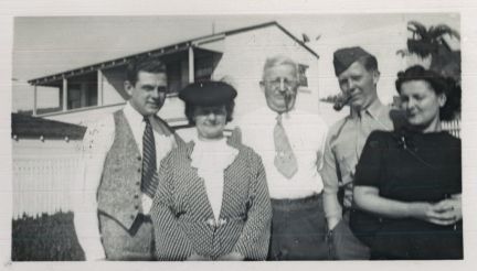 A group of people posing for a picture in front of a house