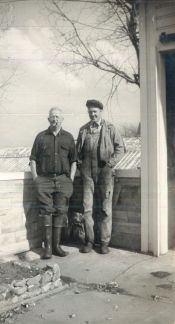 Two men are standing next to each other in a black and white photo.