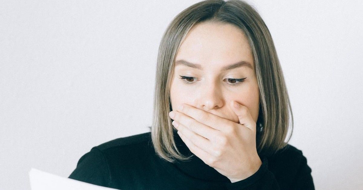 Worried attorney covers her mouth after seeing her IOLTA trust account is short.