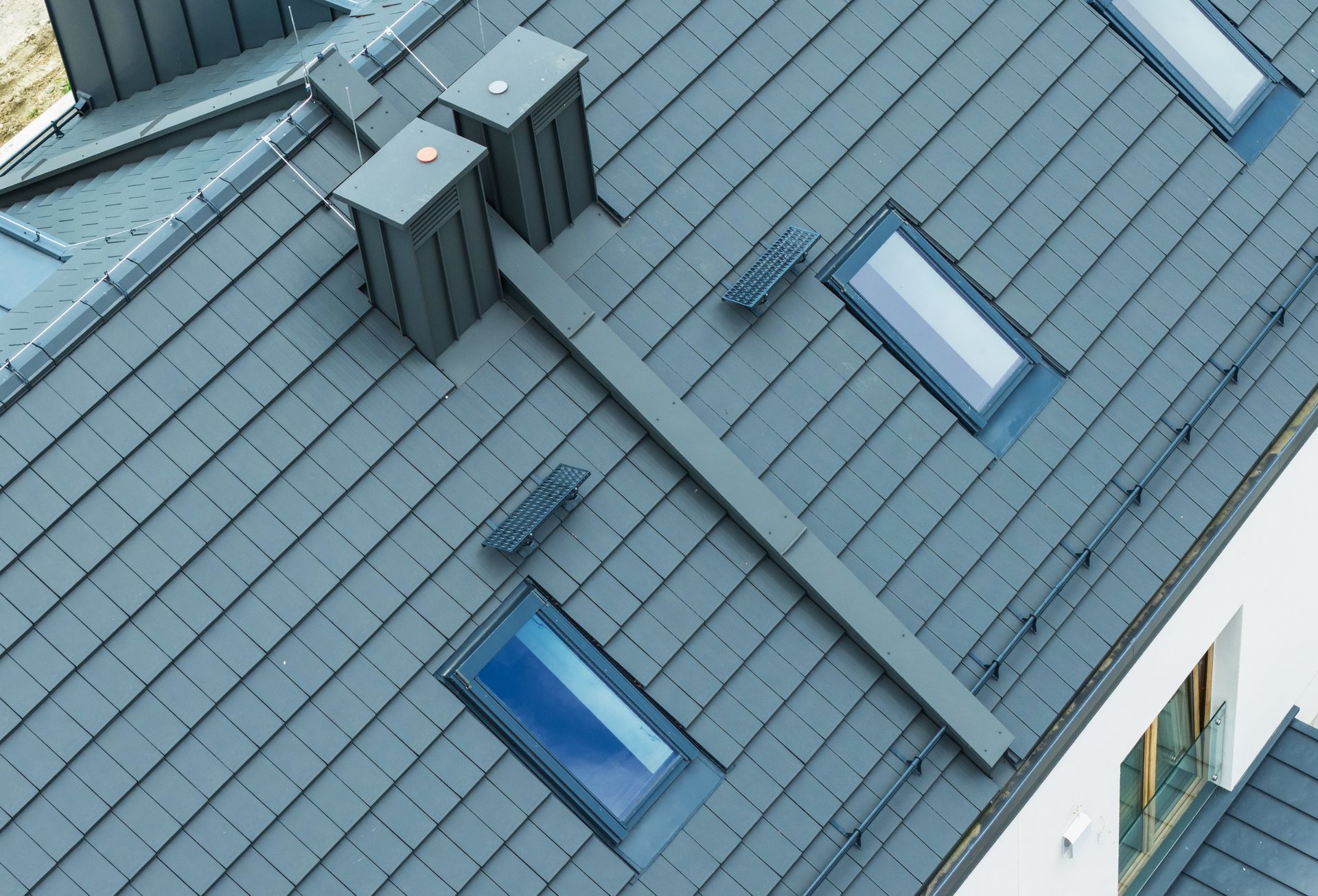 Blue metal roof with skylights and rooftop vents on a building