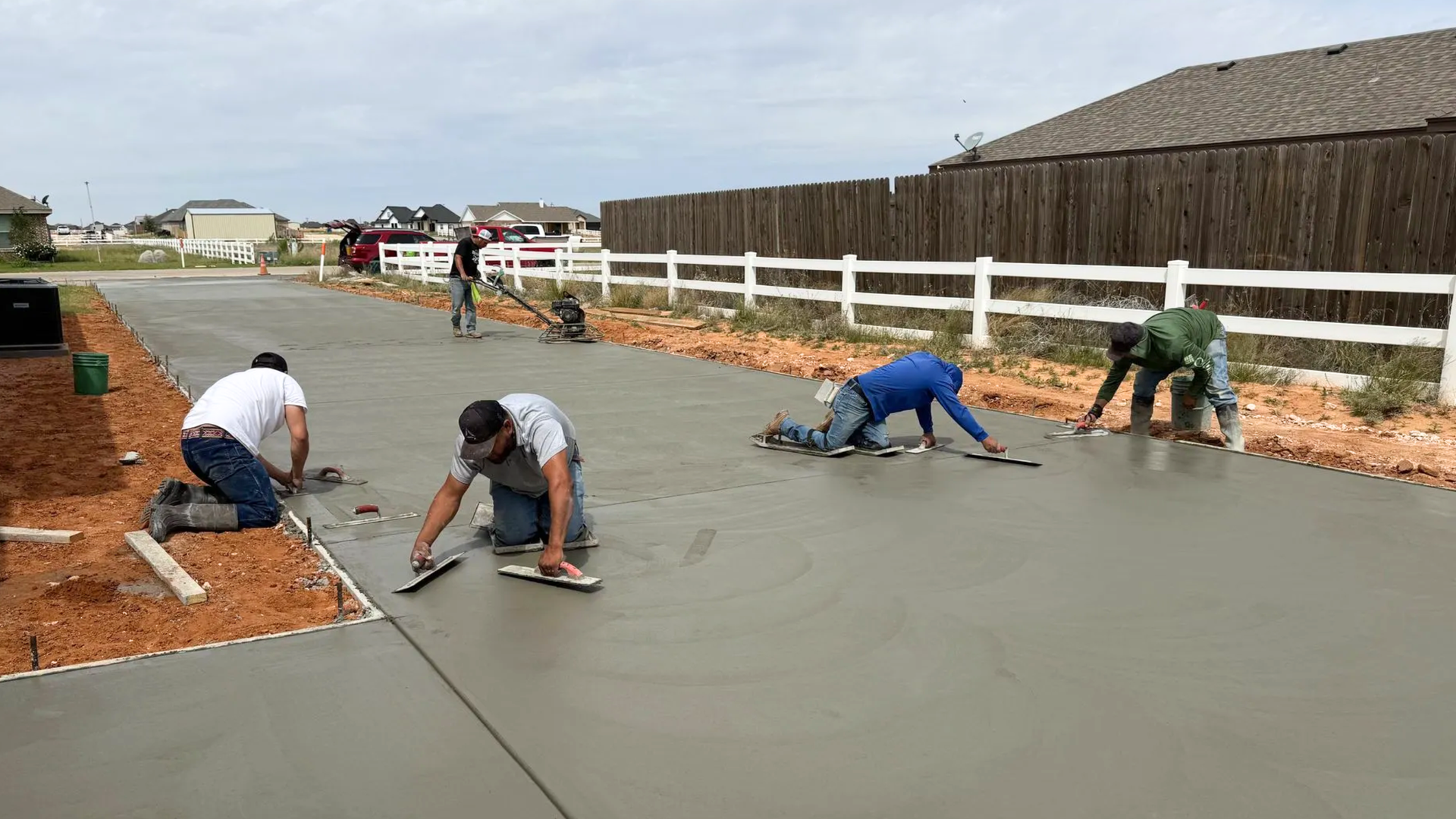  Concrete crew finishing a fresh residential driveway slab