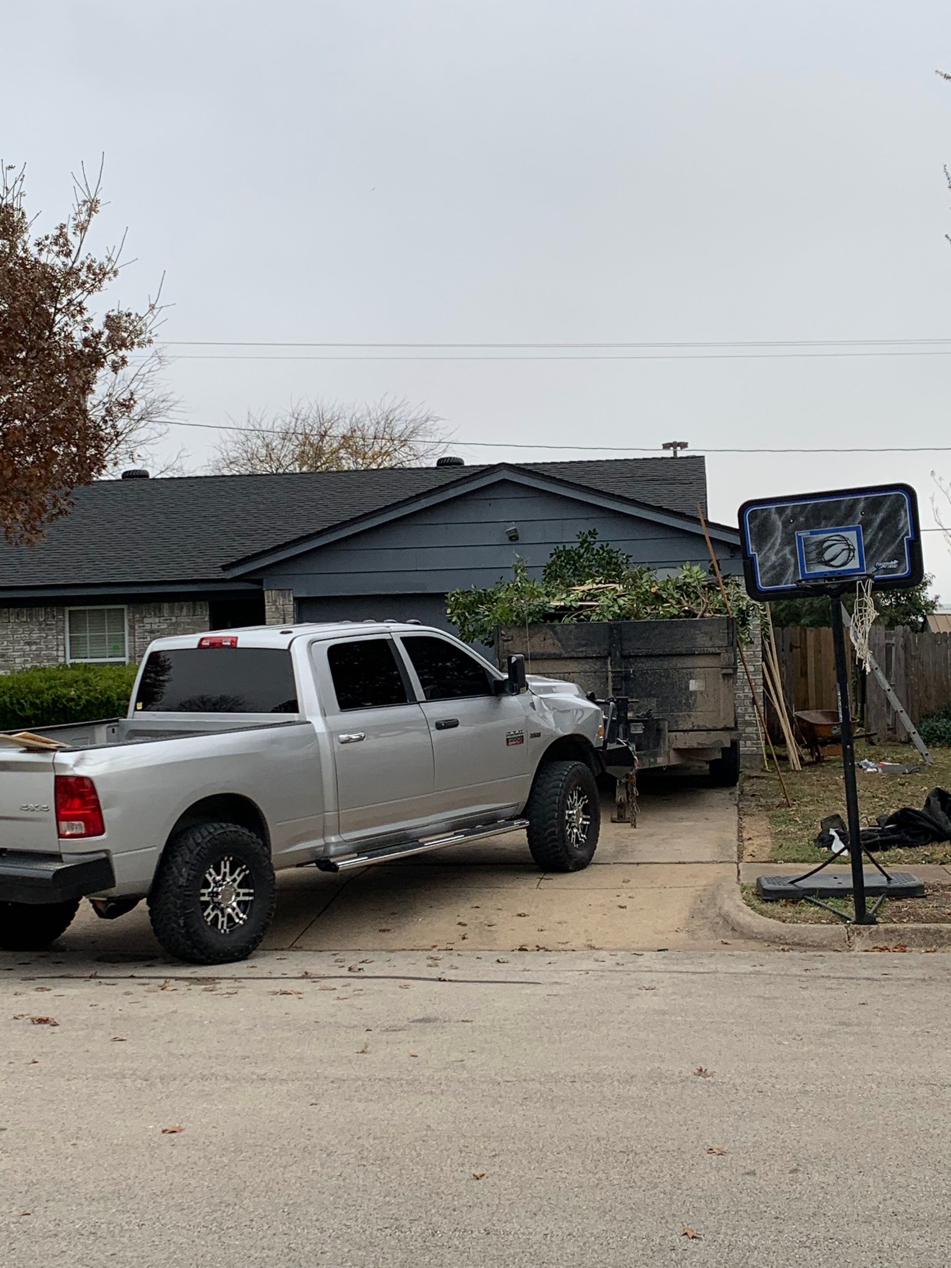 A silver truck is parked in front of a house.