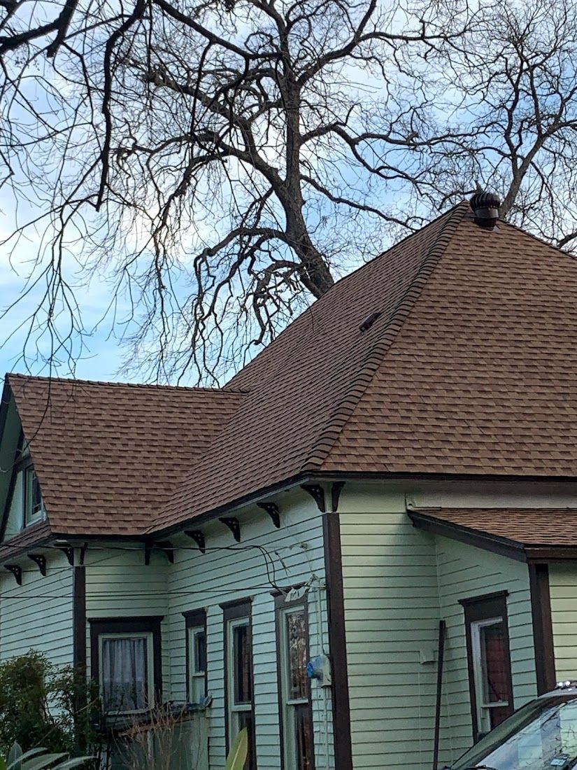 A house with a brown roof and a car parked in front of it.