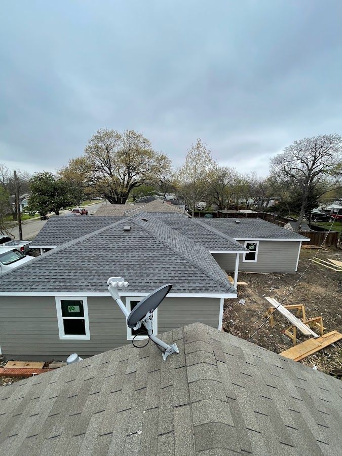 A satellite dish is sitting on the roof of a house.