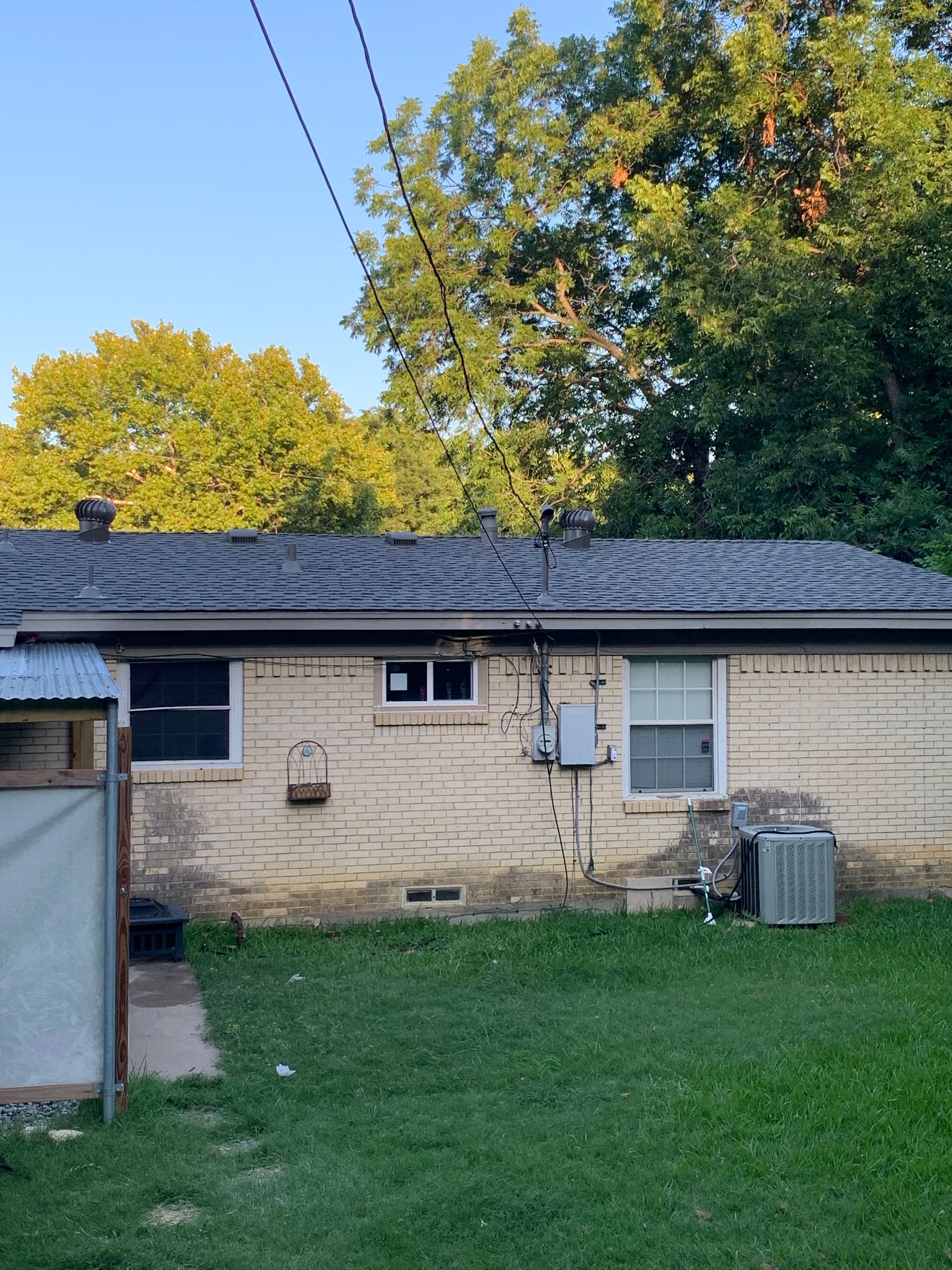 A brick house with a shed in the backyard