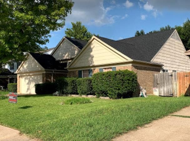 A house with a black roof and a sign that says no parking