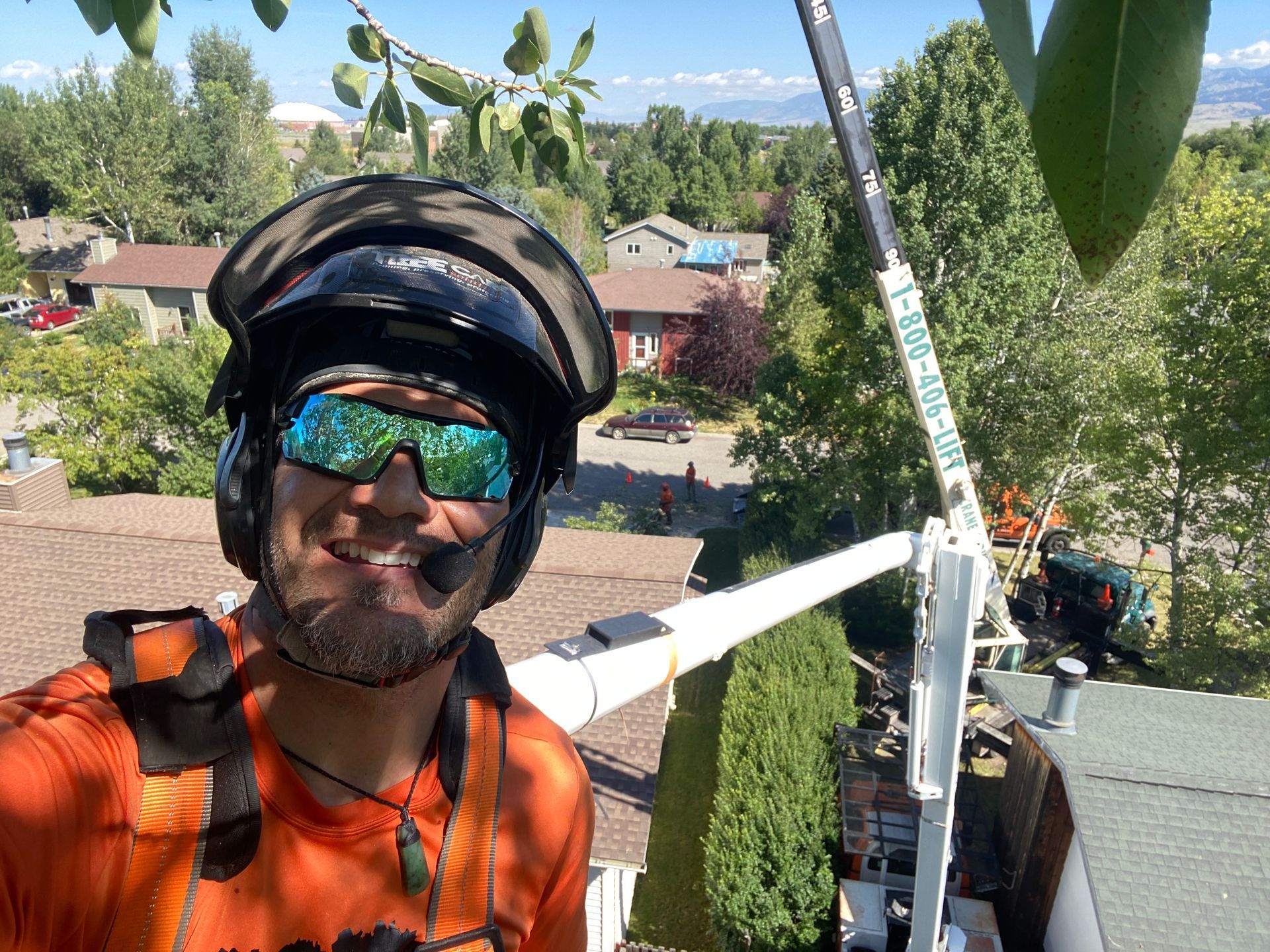 Helmeted cyclist taking a selfie on a rooftop with trees and houses in the background