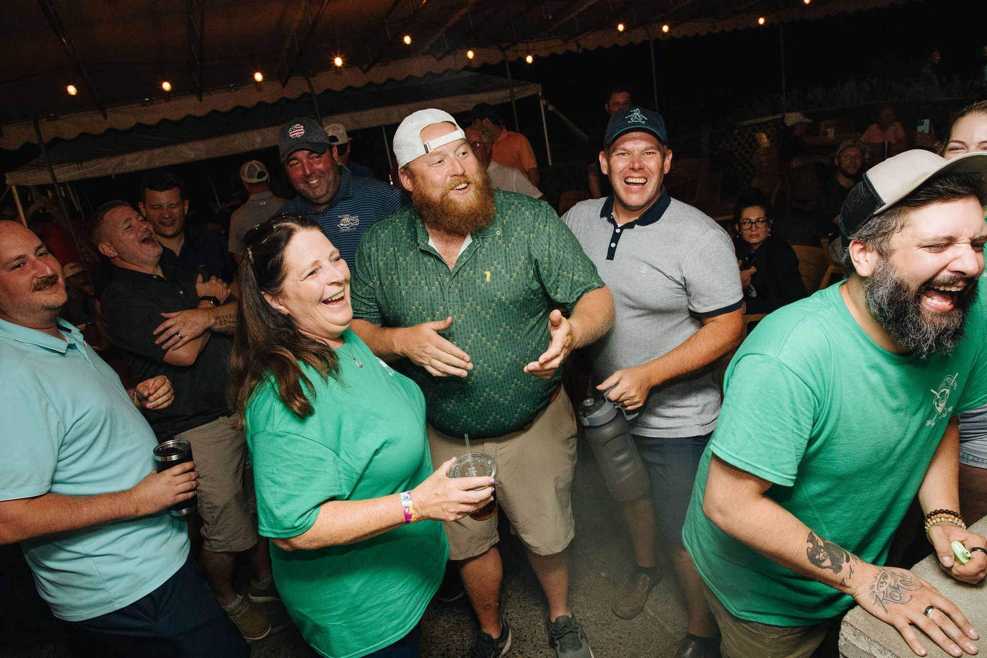 A group of people in green shirts are dancing together.