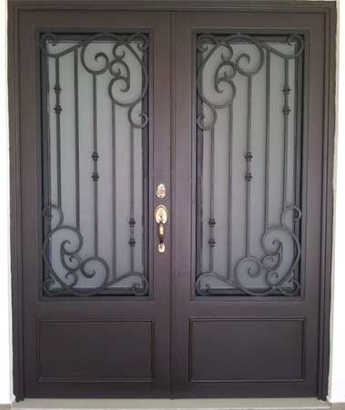 Un par de puertas de hierro forjado con remolinos sobre un fondo blanco.