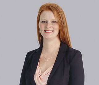 Haley Van Dyke, woman with red hair wearing a pink top and black blazer