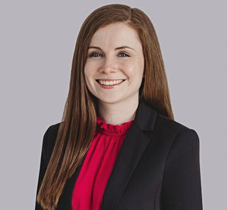 Kaitlin McLean. Woman with brown hair smiling, wearing a pink top and black blazer