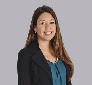Megan Feliciano, woman with dark hair, smiling, wearing a blue top and black blazer