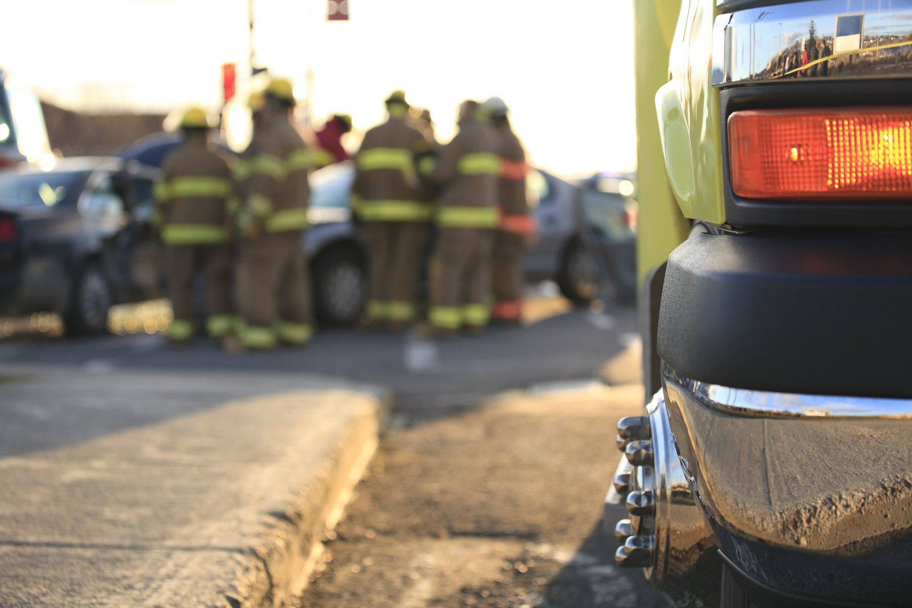 firemen standing in the background of a car